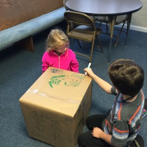 Peyton and Shane hard at work in decorating the collection boxes for winter clothing for the needy